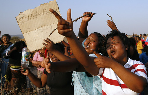 Unidentified women hold a placard that reads Piega come Piega (Phiyega)  as they protests against the police near a shooting scene at the Lonmin mine near Rustenburg, South Africa, Friday, Aug. 17, 2012. by Pan-African News Wire File Photos