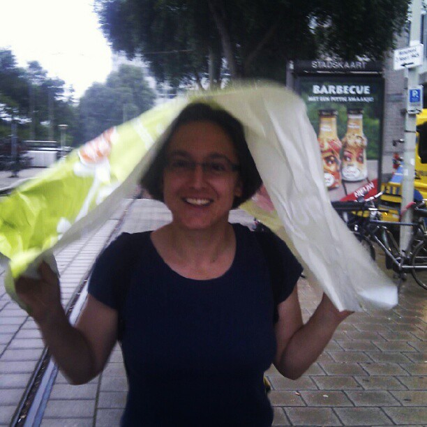 snel door regen met geïmproviseerde paraplu (met dank aan Kiosk Laan v NOI)