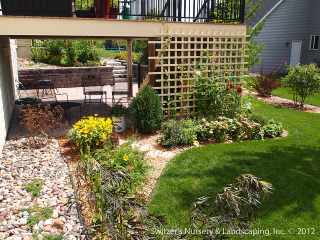 The custom made trellis and the planting bed further create the feeling of an outdoor garden room under the deck.