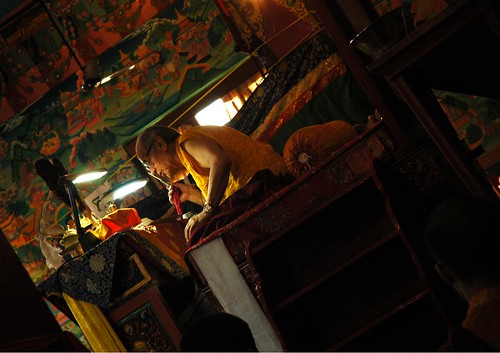 Initiation into highest yoga tantra by a world renown master, His Holiness Dagchen Sakya holds a tooth stick in his right hand while reading the transmission in Tibetan, from his throne, Tharlam Monastery of Tibetan Buddhism, Boudha, Kathmandu, Nepal by Wonderlane