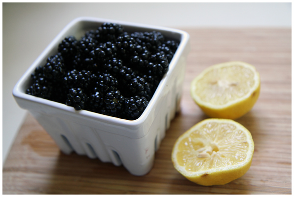 Making berry sauce with blackberries and lemons