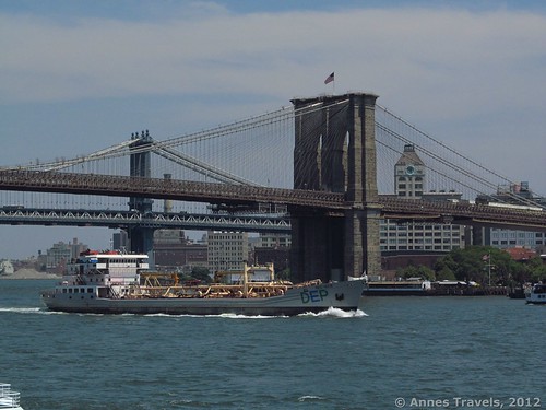 A boat passes under the Brooklyn Bridge, East River Esplanade, New York City