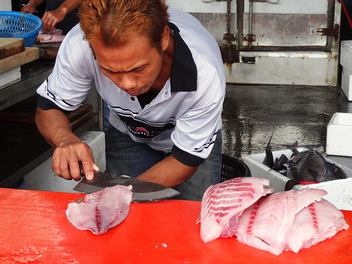 魚市裡，攤販孰練地替「琵琶魚」剝皮取肉