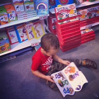 Traffic-causing tot. Timmy grabbed a book from the shelf, plopped down on the floor, then started reading, oblivious to the crowd around him. (Manila Int'l Book Fair)