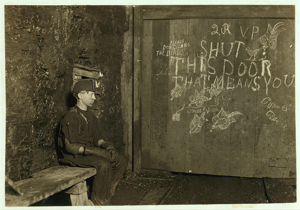 Vance, a Trapper Boy, 15 years old. Has trapped for several years in a West Va. Coal mine. $.75 a day for 10 hours work. All he does is to open and shut this door: most of the time he sits here idle, waiting for the cars to come.