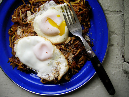fried eggs and summer squash noodles with caramelized onions