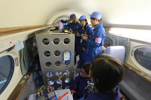 ภาพเด็กๆ กำลังติดตั้งอุปกรณ์การทดลองบนเครื่องบิน