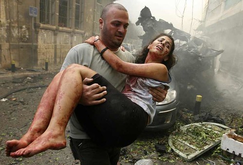 A-wounded-woman-is-carried-at-the-site-of-an-explosion-in-Ashrafieh