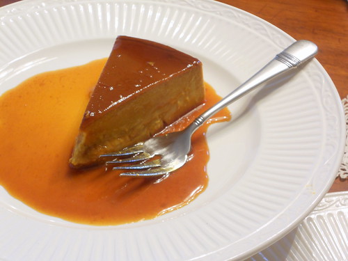  A slice of Caramel Pumpkin Latte Flan on  white plate with a fork.