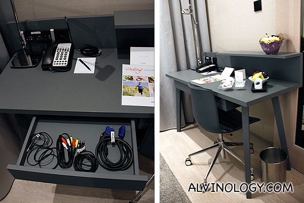 A work area in the room with a drawer containing all sorts of cables