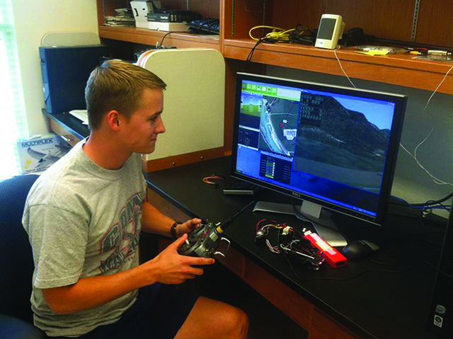 David Jones, senior in software engineering, performs a hardware-in-the-loop simulation on XPlane software to test the autopilot function that equips UAVs