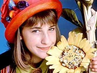 A season one photo of Blossom wearing a straw hat and cuddling up to a sunflower.