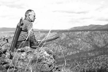Aldo Leopold seated on rimrock above the Rio Gavilan in northern Mexico while on a bow hunting trip in 1938. (Photo courtesy Aldo Leopold Foundation)