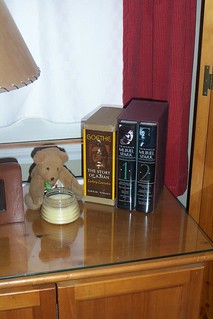 A couple of book sets sitting next to teddy bear made by Sandy from Iowa with a little bee hive candle that smells oh, so good