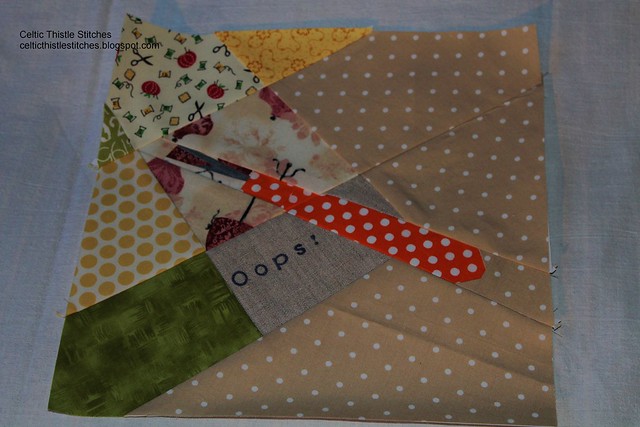 paper-pieced quilt block showing a seam ripper about to be used to correct an error in the sewing of the block 