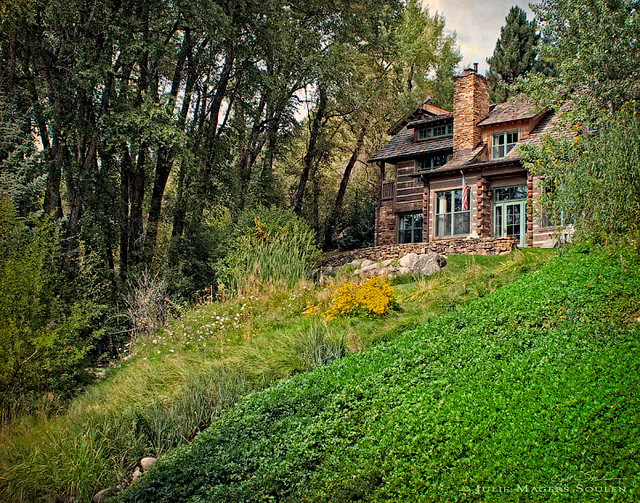 a log cabin in the woods on a hillside