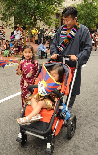 Happy Tibetan family man, his daughers, a toddler under the Tibetan flag, and his lovely young daughter in a formal silk gown, Happy Birthday to His Holiness the Great Dalai Lama, Washington D.C., USA by Wonderlane