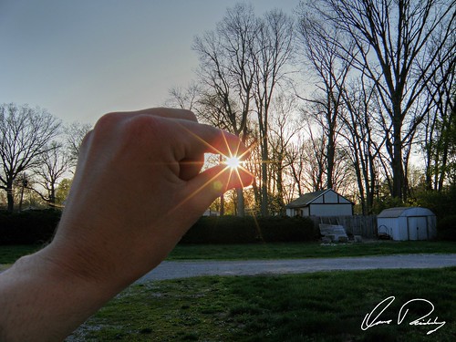 holding sun sunlight sunset pinch pinching between finger fingers