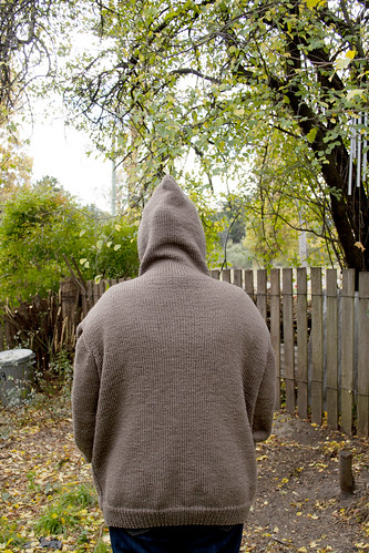 Photo of Ruth wearing the knitted jumper. Taken from behind with the hood up