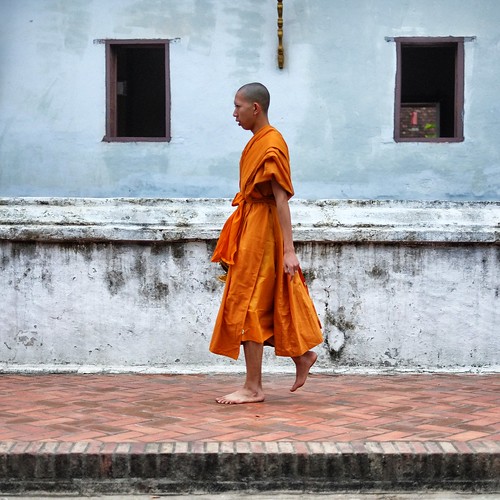 Monk walking past Wat Sensoukaram.  Luang Prabang, Laos. by daveweekes68
