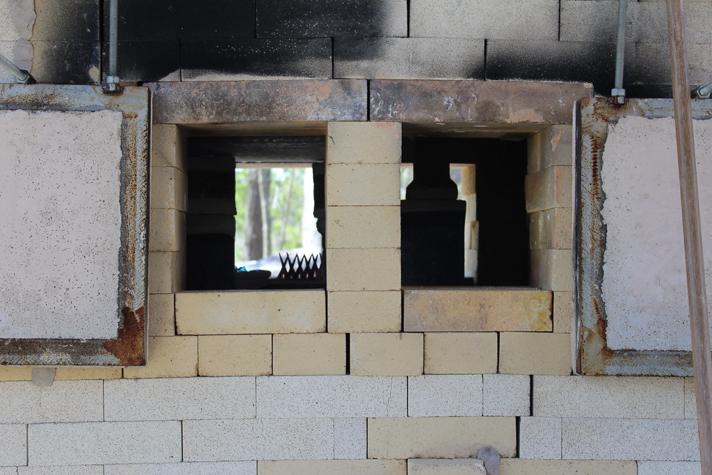 Ports for glass blowing on the side of the wood kiln.