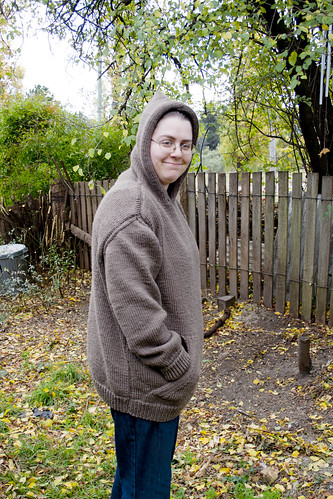 Ruth wearing the knitted jumper taken from side on with the hood up