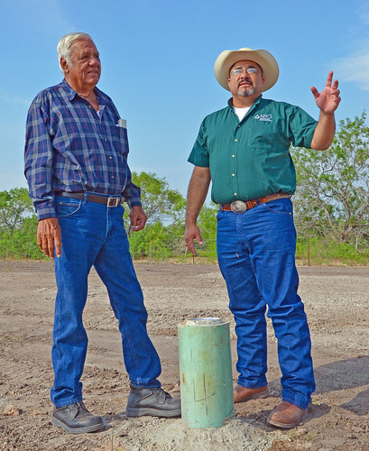 Rancher Willie Utley of Benavides, Texas and Sammy Guerra, USDA Natural Resources Conservation Service district conservationist in Benavides, Tex., discuss the successful drilling of the water well they’re standing behind. (NRCS photo/Beverly Moseley)