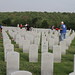 Red Cross volunteers place flags on the graves at the DFW National Cemetery.