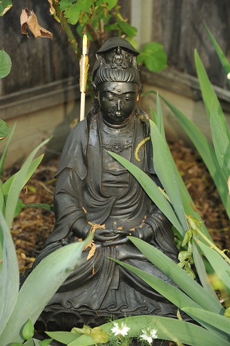 Black Quan Yin, Bodhisattva with Avalokiteshvara on her crown, garden statue, white flowers, South Bay Vajrayana, California, USA by Wonderlane