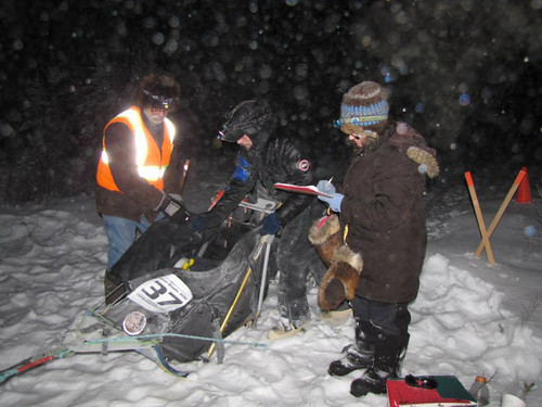 Bureau of Land Management volunteers Marnie Graham and Dennis Teitzel check in a racer at the Sourdough checkpoint for the Copper Basin 300 dog sled race in Alaska. (National Park Service)