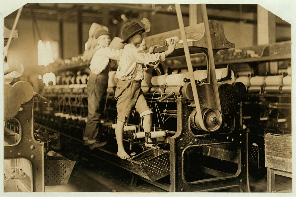 488 Macon, Ga. Lewis W. Hine 1-19-1909. Bibb Mill No. 1 Many youngsters here. Some boys were so small they had to climb up on the spinning frame to mend the broken threads and put back the empty bobbins. Location: Macon, Georgia.