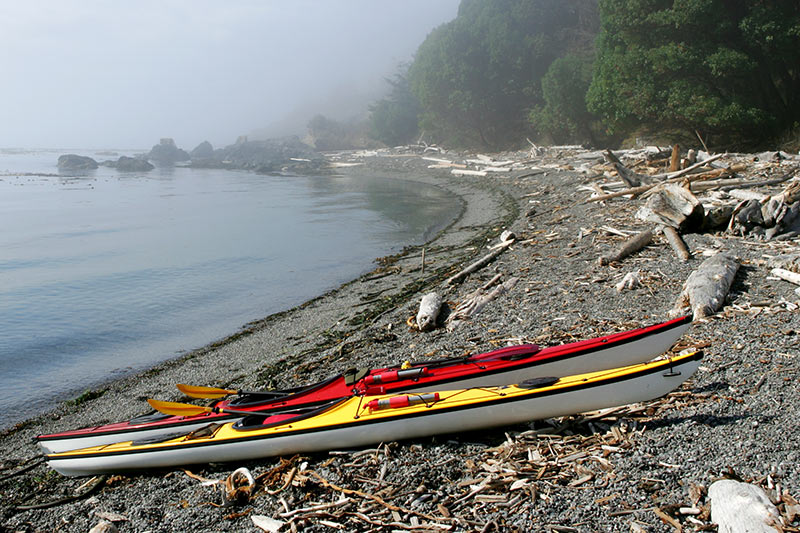 Sea kayaks on a remote beach on Vancouver Island, British Columbia, Canada.