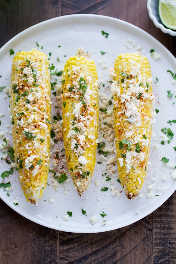Mexican Street Corn - perfect to serve at barbecues and on Cinco de Mayo! Tender corn with garlic mayo, lime juice, cotija cheese, and cilantro! #cornonthecob #mexicanstreetcorn #cincodemayo | Littlespicejar.com