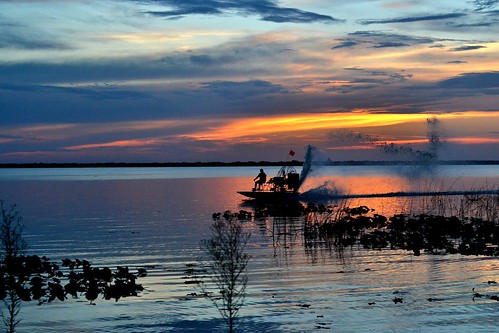 sunset sky sun lake water clouds boat