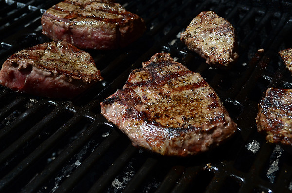 The steaks are put on the grill.