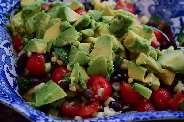 Chopped avocado is added to the salsa.