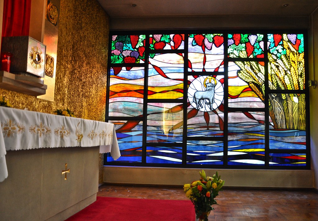 Stained glass window with light falling on Blessed Sacrement