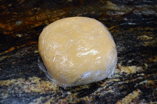 The cookie dough formed into a ball and wrapped with plastic wrap.