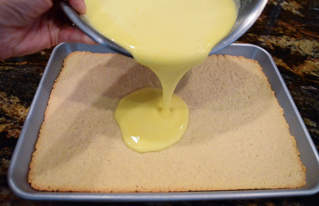 The lemon mixture being poured on top of the dough.