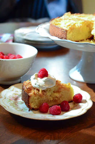 A slice of Almond Crunch Pound Cake with whipped cream and raspberries.