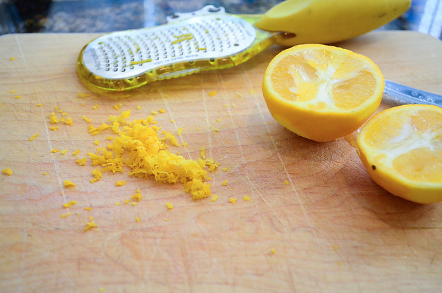 A sliced lemon and some lemon zest.