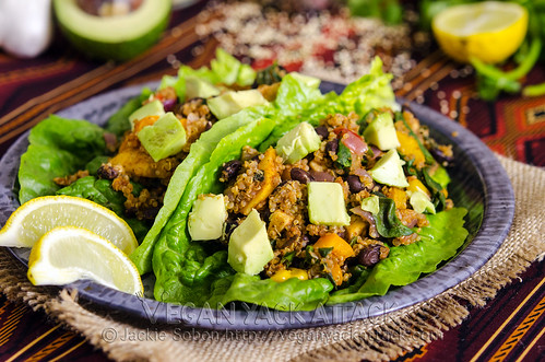Two fiesta lettuce wraps on a plate with ingredients in the background