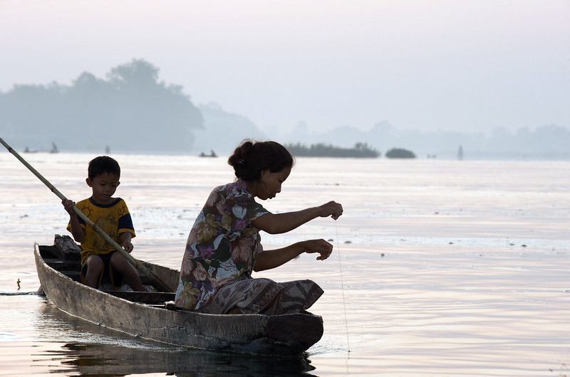 Fisherwoman checking a fishing line in Mekong, Laos. Photo by Patrick Dugan, 2009.