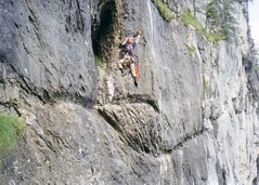 Greg Bolting to a cave on the cliff face Image