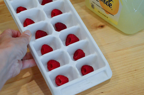 Raspberries arranged in an ice cube tray.