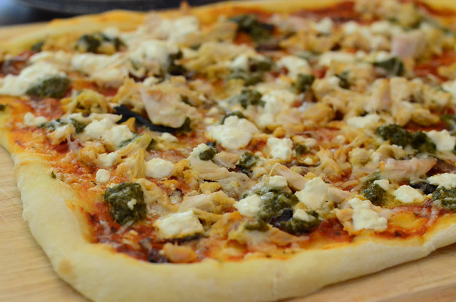 A close up of the Chicken Pesto Pizza with Caramelized Onions and Goat Cheese.