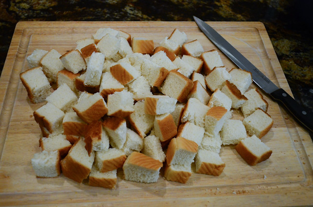 The Texas Toast is cut into cubes on a cutting board.