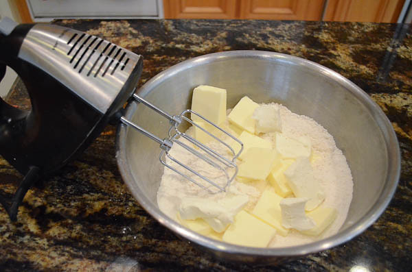 A bowl with ingredients about to be mixed by a hand mixer.