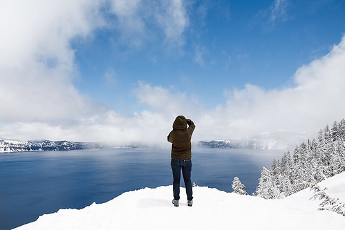 blue trees winter sky people usa white lake snow cold clouds oregon person one nationalpark spring frost photographer view unitedstates tourist vista getty craterlake rim