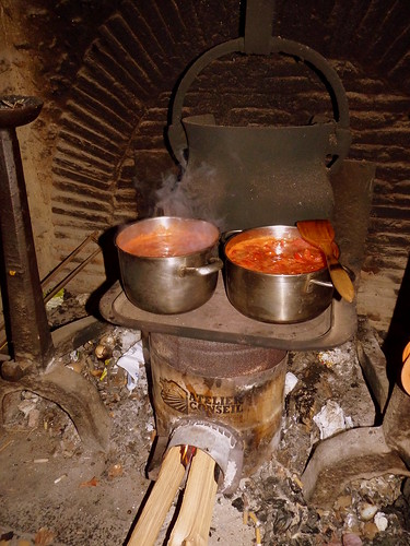 Reducing tomatoes on the rocket stove which also heats the hot water for a shower later
